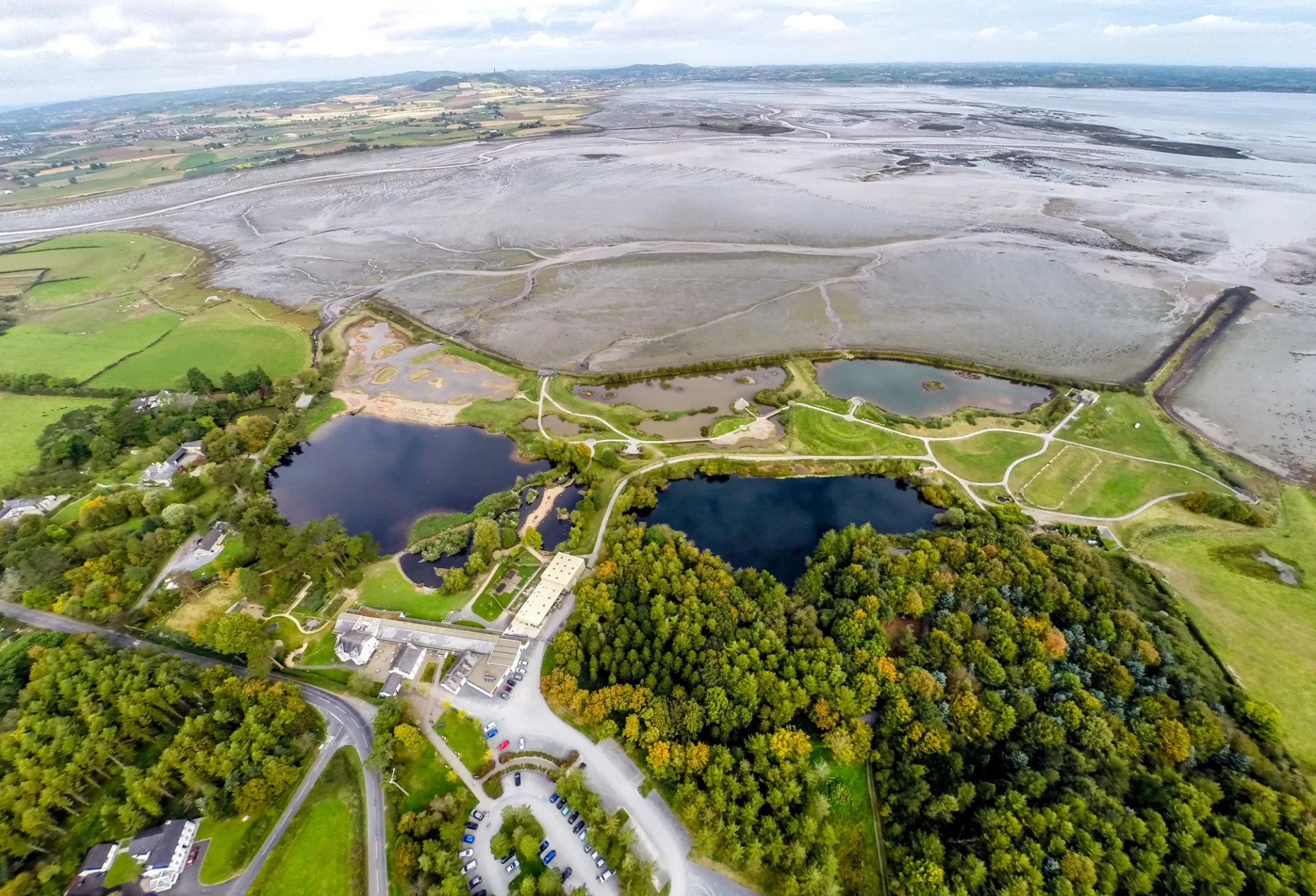 Aerial view of land and water and a large building
